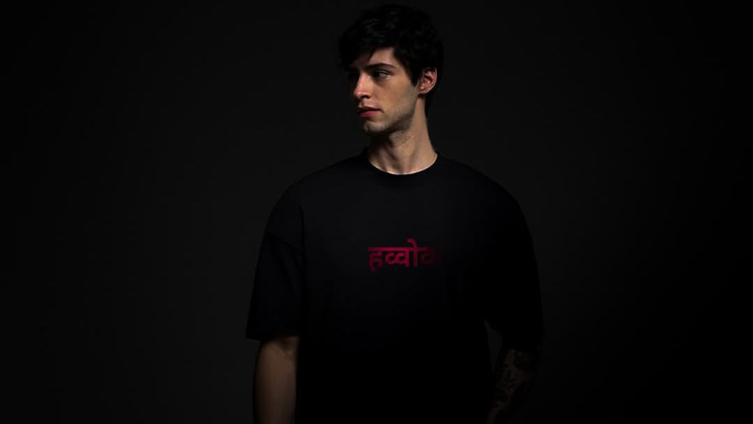 Person wearing a black t-shirt with red text on a dark background