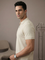 Man wearing a beige polo shirt against a neutral background