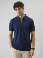 Man wearing a navy blue polo shirt against a gray background