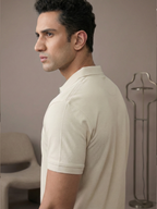 Man wearing a beige polo shirt against a neutral background